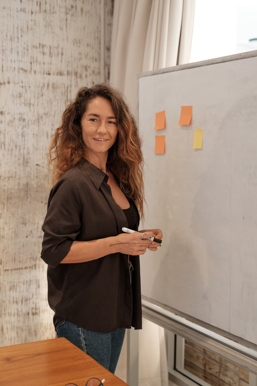 Smiling Woman Standing Near a Whiteboard